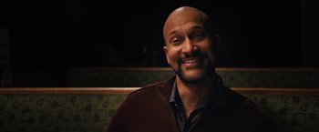 Movie still from “The Prom” (2020), directed by Ryan Murphy – A man with a bald head smiling for the camera; Close Up shot, Over the shoulder angle