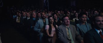 Movie still from “The Prom” (2020), directed by Ryan Murphy – A group of people sitting in front of an audience at an event; Medium shot, High angle