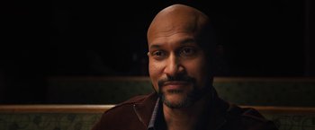 Movie still from “The Prom” (2020), directed by Ryan Murphy – A man with a bald head is looking at the camera; Close Up shot, Over the shoulder angle