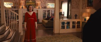Movie still from “The Prom” (2020), directed by Ryan Murphy – A woman in a red dress standing in a living room; Wide shot, Over the shoulder angle