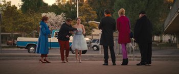 Movie still from “The Prom” (2020), directed by Ryan Murphy – A group of people standing on a sidewalk; Wide shot, Over the shoulder angle