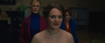 Movie still from “The Prom” (2020), directed by Ryan Murphy – A woman wearing a diamond necklace in front of two other women; Close Up shot, Over the shoulder angle