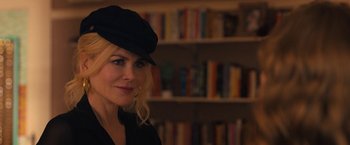 Movie still from “The Prom” (2020), directed by Ryan Murphy – A woman wearing a hat in front of a book shelf; Close Up shot, Over the shoulder angle