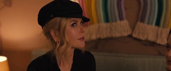 Movie still from “The Prom” (2020), directed by Ryan Murphy – A woman wearing a black hat looking to her left; Close Up shot, Over the shoulder angle