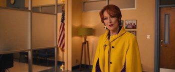 Movie still from “The Prom” (2020), directed by Ryan Murphy – A woman in a yellow coat standing in a room; Medium shot, Over the shoulder angle