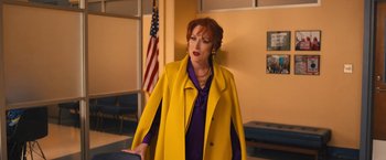 Movie still from “The Prom” (2020), directed by Ryan Murphy – A woman in a yellow coat standing in front of an american flag; Medium shot, Over the shoulder angle