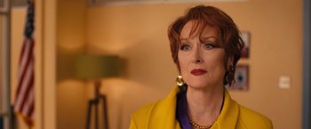 Movie still from “The Prom” (2020), directed by Ryan Murphy – An older woman with red hair wearing a yellow jacket; Close Up shot, Over the shoulder angle