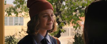 Movie still from “The Prom” (2020), directed by Ryan Murphy – A young woman wearing a red hat and a tie; Close Up shot, Over the shoulder angle