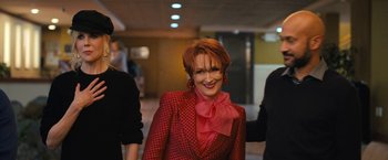 Movie still from “The Prom” (2020), directed by Ryan Murphy – A woman in a red jacket smiling for the camera; Medium shot, Over the shoulder angle