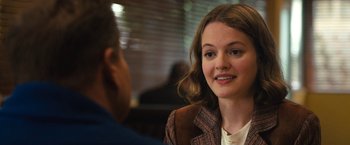 Movie still from “The Prom” (2020), directed by Ryan Murphy – A woman sitting in front of a man in a suit; Close Up shot, Over the shoulder angle