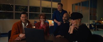 Movie still from “The Prom” (2020), directed by Ryan Murphy – A group of people sitting around a table looking at a computer screen; Medium shot, High angle