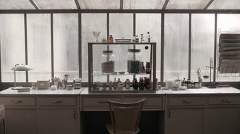 Movie still from “The Queen's Gambit” (2020), directed by Scott Frank – A desk with a lot of jars on top of the desk; Wide shot, High angle