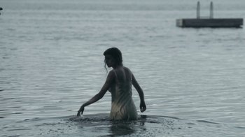 Movie still from “The Queen's Gambit” (2020), directed by Scott Frank – A woman standing in a body of water; Wide shot, High angle