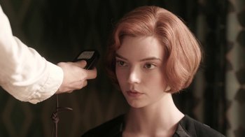 Movie still from “The Queen's Gambit” (2020), directed by Scott Frank – A woman with red hair is getting her hair cut; Close Up shot, Over the shoulder angle