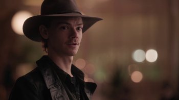 A man wearing a hat and a leather vest