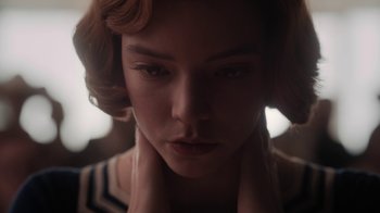 Movie still from “The Queen's Gambit” (2020), directed by Scott Frank – A woman's face with her hands on her neck; Close Up shot, Low angle