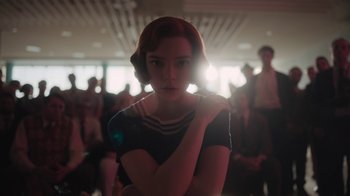 Movie still from “The Queen's Gambit” (2020), directed by Scott Frank – A woman with red hair is standing in a room; Medium shot, Low angle