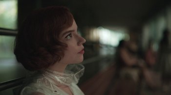Movie still from “The Queen's Gambit” (2020), directed by Scott Frank – A woman with red curly hair looking to her left; Close Up shot, Low angle