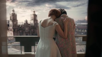 Movie still from “The Queen's Gambit” (2020), directed by Scott Frank – Two women are hugging in front of a city skyline; Medium shot, Over the shoulder angle