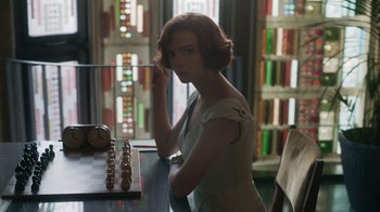 Movie still from “The Queen's Gambit” (2020), directed by Scott Frank – A woman standing in front of a chess board; Medium shot, Over the shoulder angle