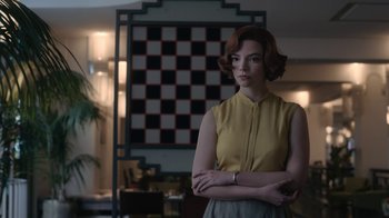 Movie still from “The Queen's Gambit” (2020), directed by Scott Frank – A woman standing in front of a checkerboard wall; Medium shot, Over the shoulder angle