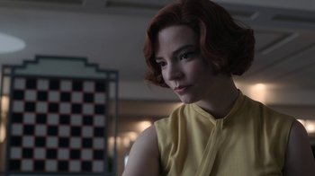 Movie still from “The Queen's Gambit” (2020), directed by Scott Frank – A woman with red hair and a yellow shirt; Close Up shot, Low angle