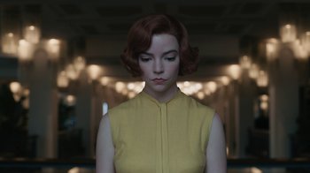 Movie still from “The Queen's Gambit” (2020), directed by Scott Frank – A woman with red hair and a yellow dress; Close Up shot, Low angle
