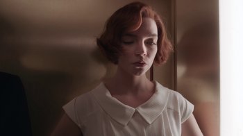 Movie still from “The Queen's Gambit” (2020), directed by Scott Frank – A woman with red curly hair wearing a white shirt; Close Up shot, Low angle