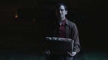 A man holding a box in a dark room