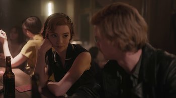 Movie still from “The Queen's Gambit” (2020), directed by Scott Frank – A woman sitting next to a man in a room; Close Up shot, Over the shoulder angle