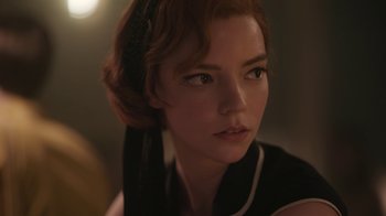 Movie still from “The Queen's Gambit” (2020), directed by Scott Frank – A person wearing a black and white outfit; Close Up shot, Over the shoulder angle