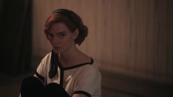 Movie still from “The Queen's Gambit” (2020), directed by Scott Frank – A woman with red hair wearing a black headband; Medium shot, High angle
