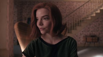 Movie still from “The Queen's Gambit” (2020), directed by Scott Frank – A woman with red hair is sitting in a room; Close Up shot, Over the shoulder angle