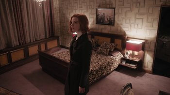 Movie still from “The Queen's Gambit” (2020), directed by Scott Frank – A woman standing in front of a bed in a room; Wide shot, High angle