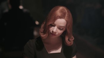 Movie still from “The Queen's Gambit” (2020), directed by Scott Frank – A woman with red hair is looking down at her face; Close Up shot, High angle