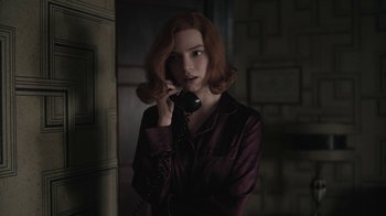 Movie still from “The Queen's Gambit” (2020), directed by Scott Frank – A woman with red hair talking on a phone; Medium shot, Low angle