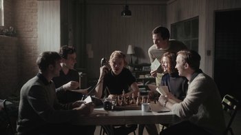 Movie still from “The Queen's Gambit” (2020), directed by Scott Frank – A group of people sitting at a table playing chess; Medium shot, High angle