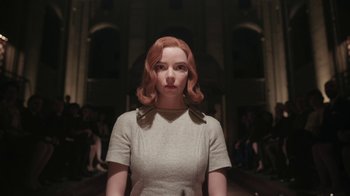 Movie still from “The Queen's Gambit” (2020), directed by Scott Frank – A woman with red hair standing in front of a crowd of onlookers; Close Up shot, Low angle