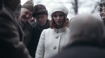Movie still from “The Queen's Gambit” (2020), directed by Scott Frank – A woman in a white coat and a white hat; Medium shot, Over the shoulder angle