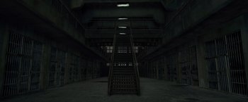 Movie still from “The Raid 2” (2014), directed by Gareth Evans – A dark room with a staircase leading up to the top of the stairs; Extreme Wide shot, Low angle