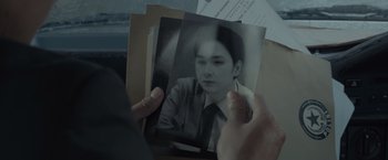 Movie still from “The Raid 2” (2014), directed by Gareth Evans – A person holding a picture of a man in a suit; Extreme Close Up shot, High angle