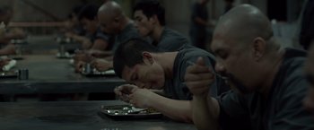 Movie still from “The Raid 2” (2014), directed by Gareth Evans – A group of men sitting at a table eating food; Medium shot, High angle