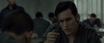 Movie still from “The Raid 2” (2014), directed by Gareth Evans – A young man holding a gun in a room; Close Up shot, Over the shoulder angle