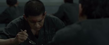 Movie still from “The Raid 2” (2014), directed by Gareth Evans – A man with a bandage on his head and face; Close Up shot, Over the shoulder angle