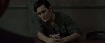 Movie still from “The Raid 2” (2014), directed by Gareth Evans – A man sitting at a table with his arms crossed; Close Up shot, Over the shoulder angle