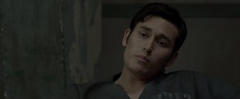 Movie still from “The Raid 2” (2014), directed by Gareth Evans – A young man is sitting in a dark room; Close Up shot, Low angle