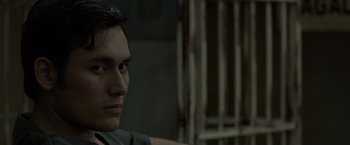 Movie still from “The Raid 2” (2014), directed by Gareth Evans – A person sitting in front of a fence; Close Up shot, Over the shoulder angle