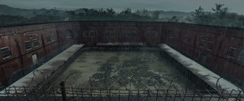 Movie still from “The Raid 2” (2014), directed by Gareth Evans – A pool of water in front of a building; Extreme Wide shot, High angle