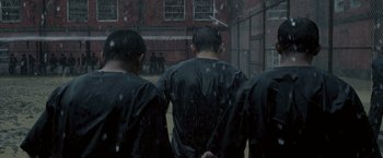 Movie still from “The Raid 2” (2014), directed by Gareth Evans – A group of people standing in the rain; Medium shot, High angle