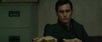 Movie still from “The Raid 2” (2014), directed by Gareth Evans – A man in a black jacket holding a brown paper bag; Close Up shot, Over the shoulder angle
